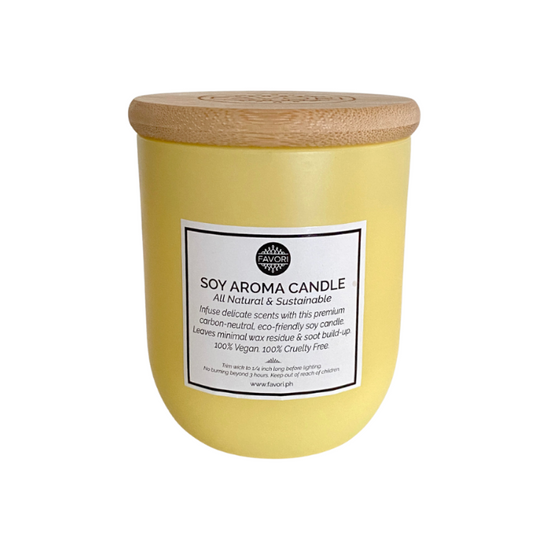 A yellow Merry Berry Soy Aroma Candle (SAC) scented with FAVORI oil, with a wooden lid and a label detailing natural and eco-friendly attributes.