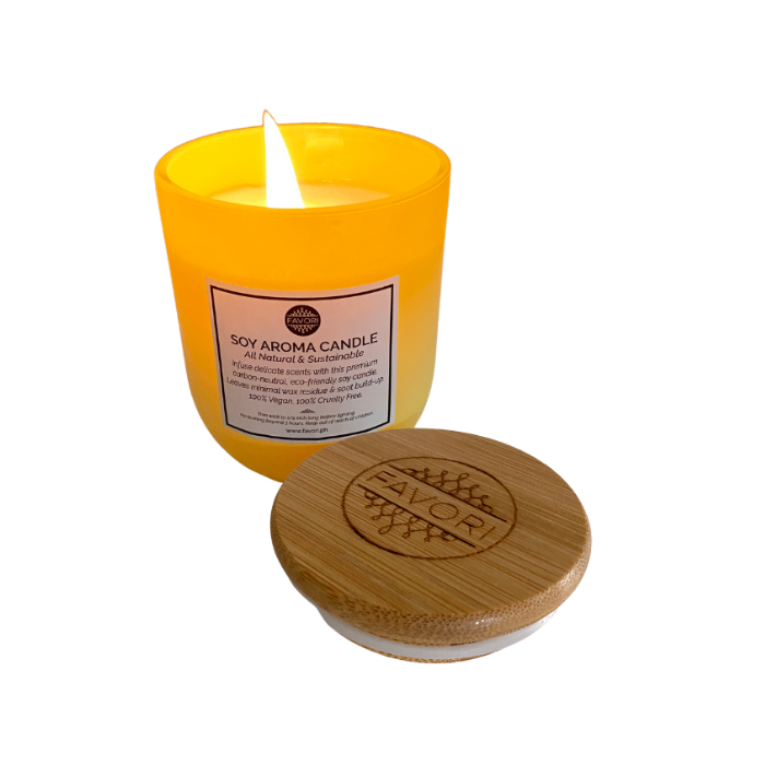 A lit Merry Berry Soy Aroma Candle (SAC) in a yellow container with a wooden lid beside it. Made by FAVORI Scents.