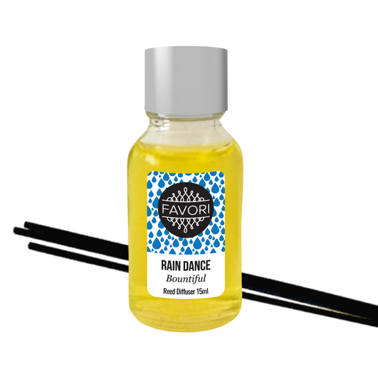 A small glass bottle labeled "FAVORI Rain Dance Mini Reed Diffuser oil 15ml" with yellow liquid and three black fiber reed sticks.