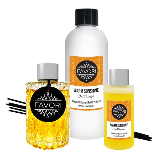 Three Warm Sunshine Trio Reed Diffuser (TRD) aroma products, including a reed diffuser, refill bottle, and a smaller bottle, with black reed sticks. Brand Name: FAVORI Scents