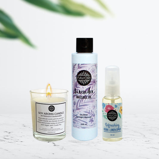 Aromatherapy products including a FAVORI Scents lit soy aroma candle, lavender massage oil, and air spray displayed on a tabletop.