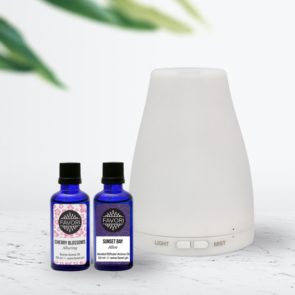 Aroma diffuser with two bottles of FAVORI essential oils, cherry blossoms, and sunset bay scents.