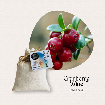 A burlap pouch of FAVORI Scents PAD, labeled Cranberry Wine aroma diffuser oil, beside fresh cranberries.