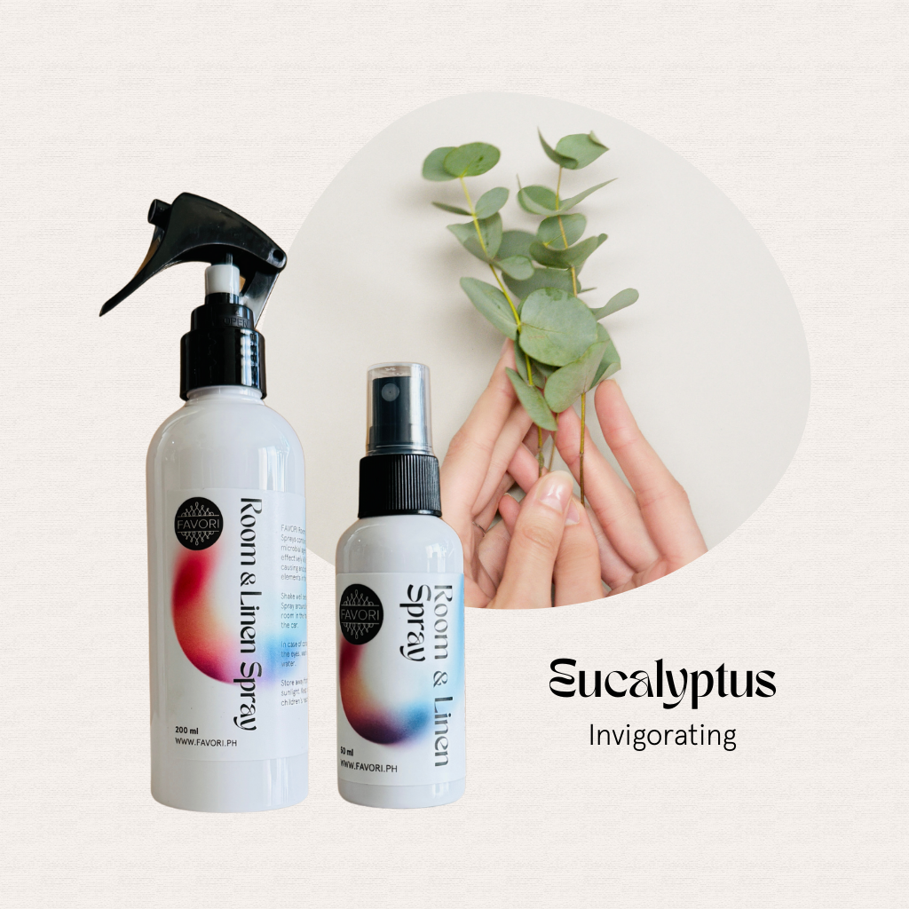 Two hands hold eucalyptus leaves; two FAVORI Scents Regular Room & Linen Air Sprays sit on a light background.