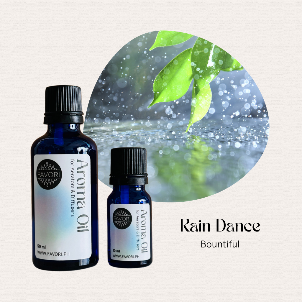 Two blue bottles of long-lasting FAVORI Scents AD Aroma Oils with rain, leaves, and Rain Dance Bountiful text.