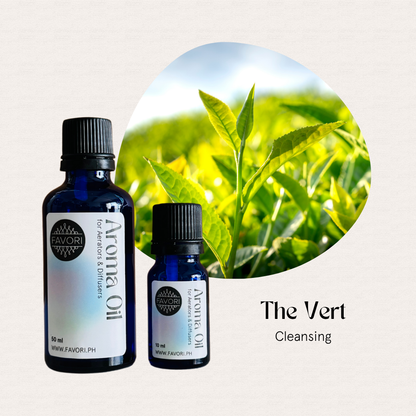 Two blue bottles of FAVORI Scents Aerator/Diffuser Aroma Oils with tea leaves on a light background.