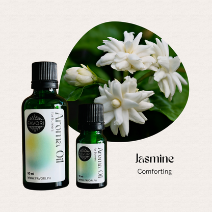 Two green bottles of FAVORI Scents Burner Aroma Oils beside white jasmine flowers and Comforting below.