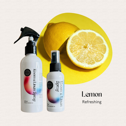 Two FAVORI Scents Regular Room & Linen Air Spray bottles beside fresh lemons on a yellow background.
