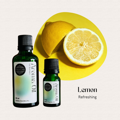 Two green FAVORI Scents Burner Aroma Oils labeled Lemon Refreshing beside a halved lemon on yellow.