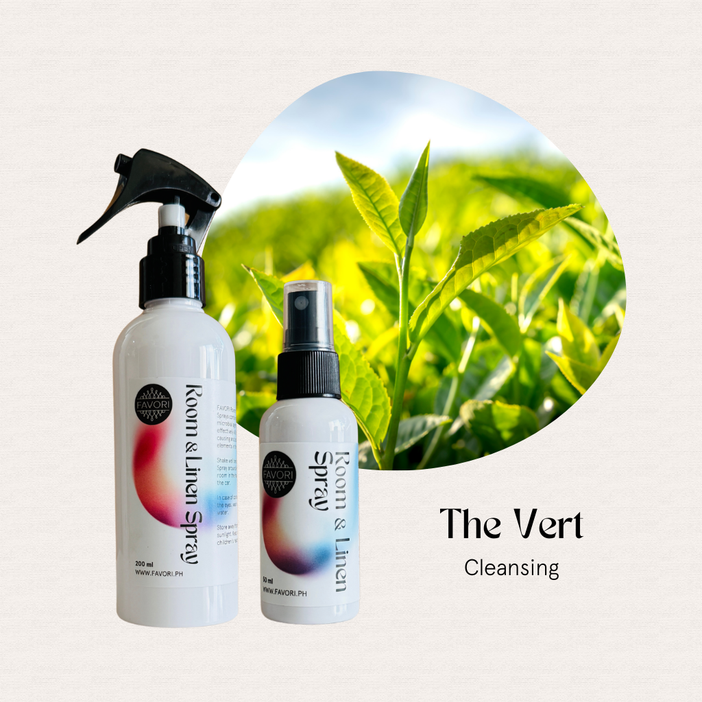 Two white FAVORI Scents Regular Room & Linen Air Sprays with colorful labels beside green tea leaves.