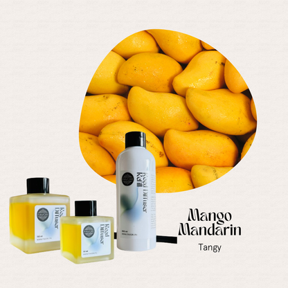 A group of ripe mangoes and three FAVORI Scents Mango Mandarin Trio Reed Diffusers labeled Tangy.