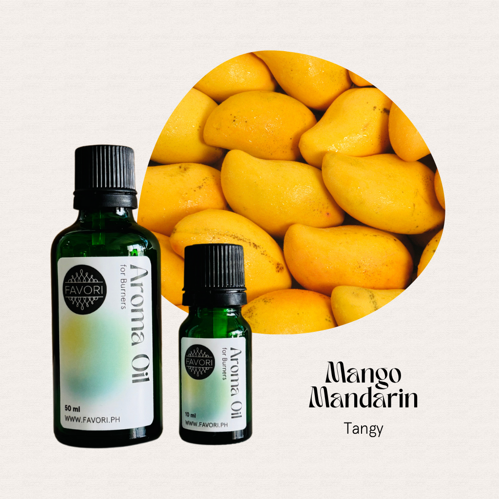 Two FAVORI Scents Burner Aroma Oils in Mango Mandarin scent stand before ripe mangoes. Text: Tangy.