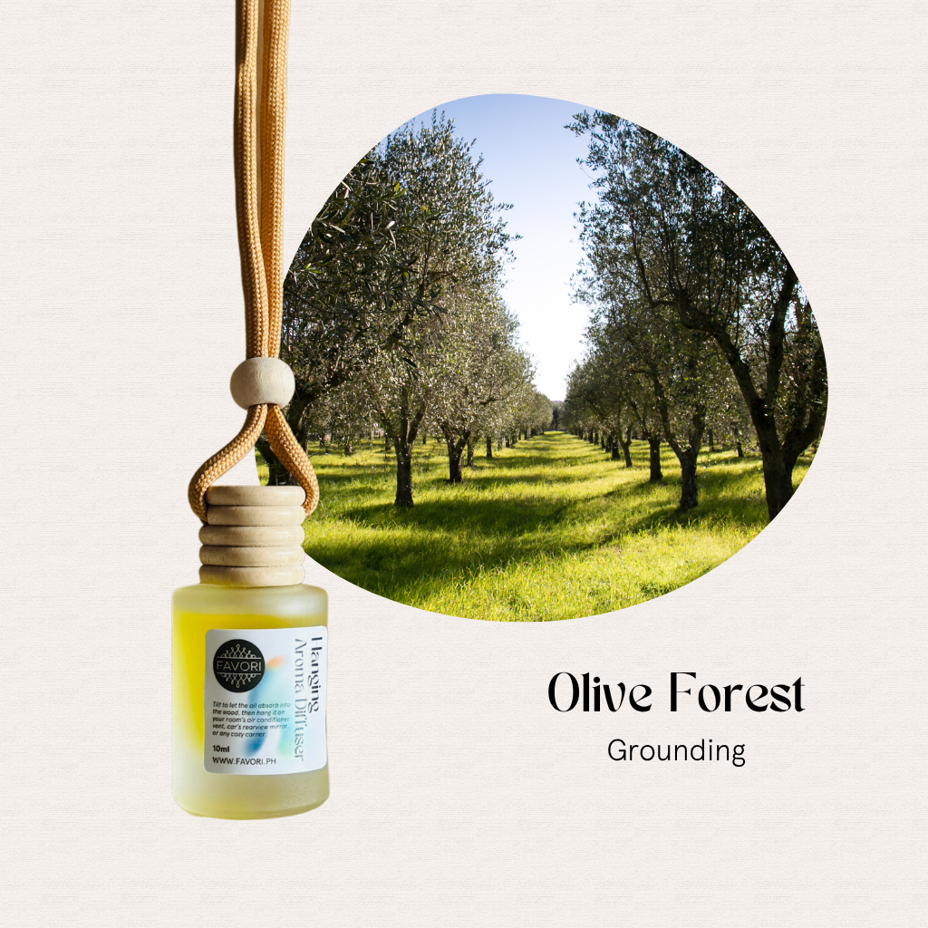 A FAVORI Scents Hanging Aroma Diffuser (HAD) labeled Olive Forest hangs by a sunlit olive tree grove.