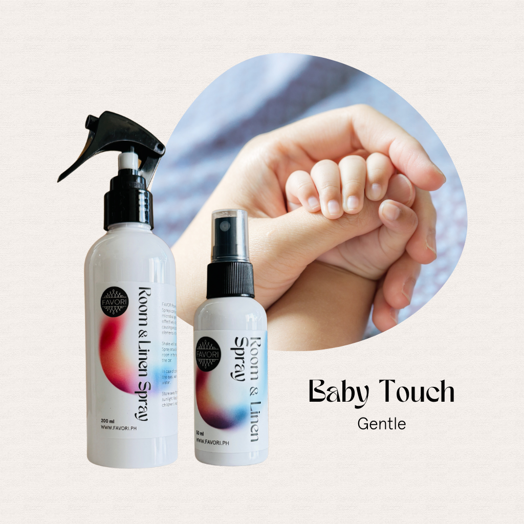 Two bottles of FAVORI Scents Regular Room & Linen Air Spray with an adult holding a babys hand in the background.