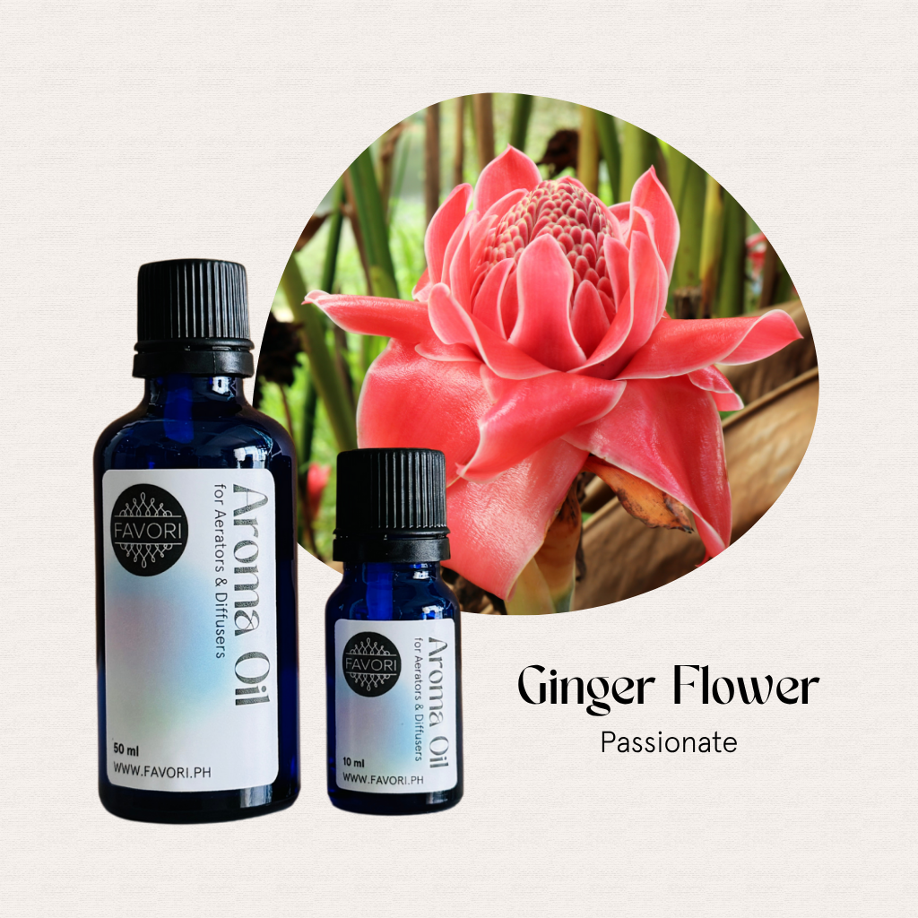 Two blue bottles of FAVORI Scents AD Aroma Oils beside a pink ginger flower with green leaves.