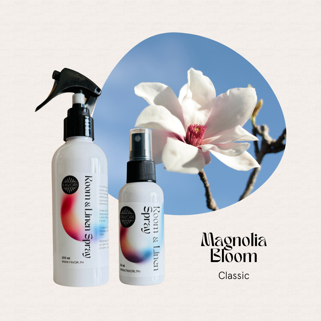 Two FAVORI Scents Regular Room & Linen Air Sprays beside a blooming magnolia under a blue sky.