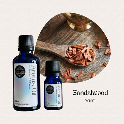 Two blue FAVORI Scents AD Aroma Oils and a wooden spoon with sandalwood chips on a light background.