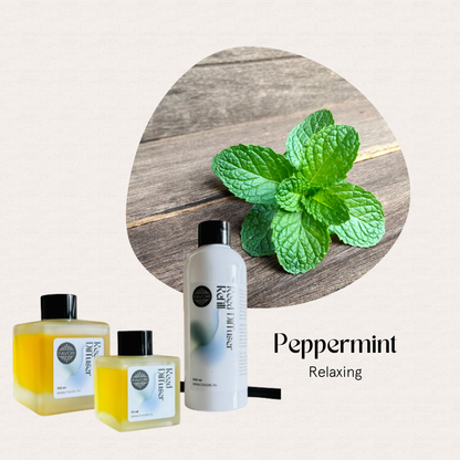 Peppermint leaves with FAVORI Scents Peppermint Trio Reed Diffuser (TRD) on wood, for relaxing aromatherapy.