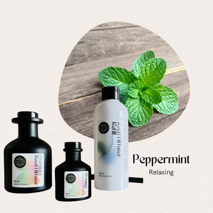 Three black and white FAVORI Scents Peppermint Trio Premium Reed Diffuser bottles with peppermint on wood background.