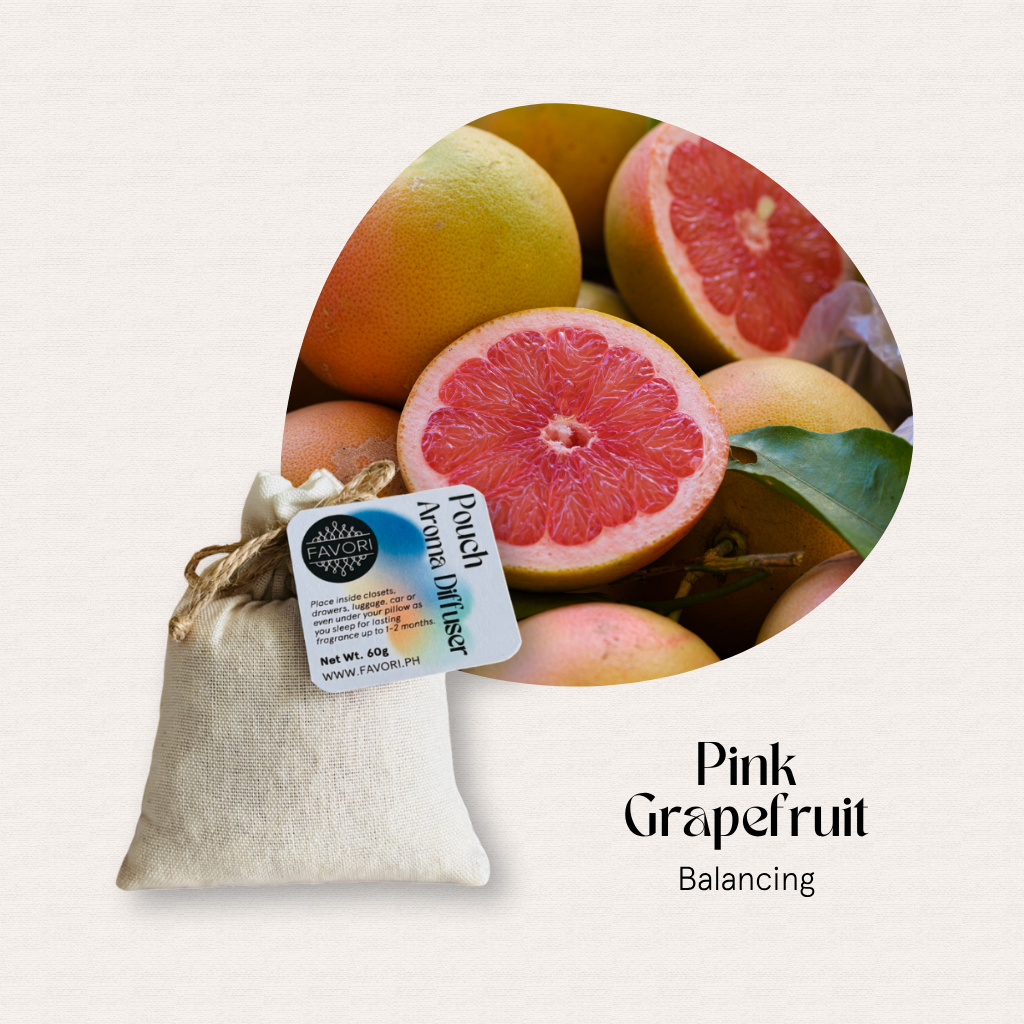 A FAVORI Scents Pouch Aroma Diffuser (PAD) with Pink Grapefruit beside fresh, sliced pink grapefruits.