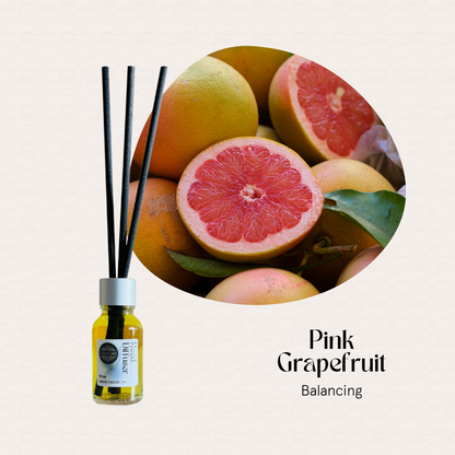 A FAVORI Scents Mini Reed Diffuser (MRD) with fiber sticks stands beside fresh whole and halved grapefruits.