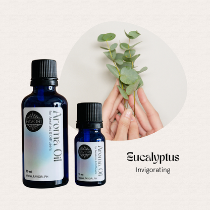 Two FAVORI Scents AD Aroma Oils beside hands holding eucalyptus leaves for a long-lasting scent.