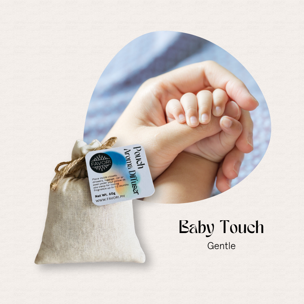 A babys hand grasps a finger, with a FAVORI Scents Pouch Aroma Diffuser (PAD) in the foreground.