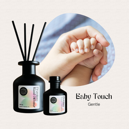 Two FAVORI Scents Baby Touch Premium Reed Diffusers with black reeds beside an adult hand holding a baby’s.