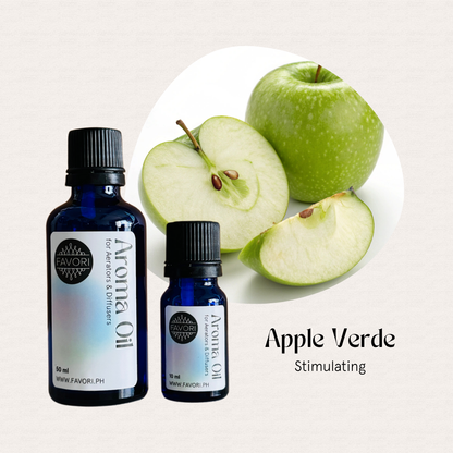 Two blue FAVORI Scents Aroma Oils (AD) bottles beside sliced and whole green apples.