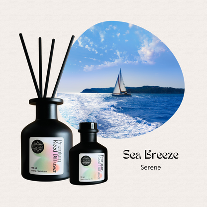 Two FAVORI Scents Sea Breeze Premium Reed Diffusers add lasting aroma beside a sailboat photo on the blue ocean.