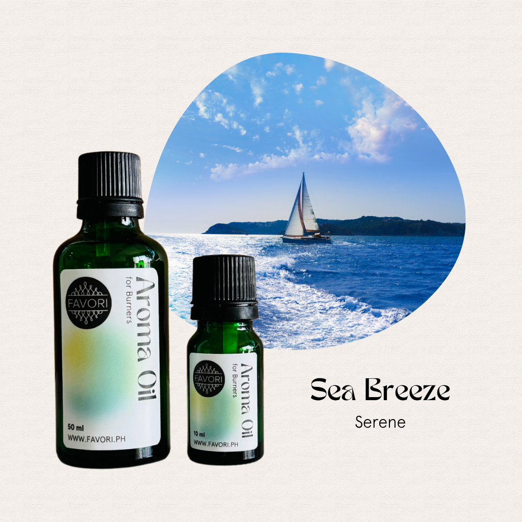 Two FAVORI Scents Burner Aroma Oils labeled Sea Breeze Serene, set before an ocean view with a sailboat.