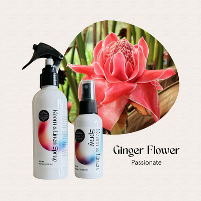 Two FAVORI Scents Regular Room & Linen Air Sprays sit before a vibrant pink ginger flower.
