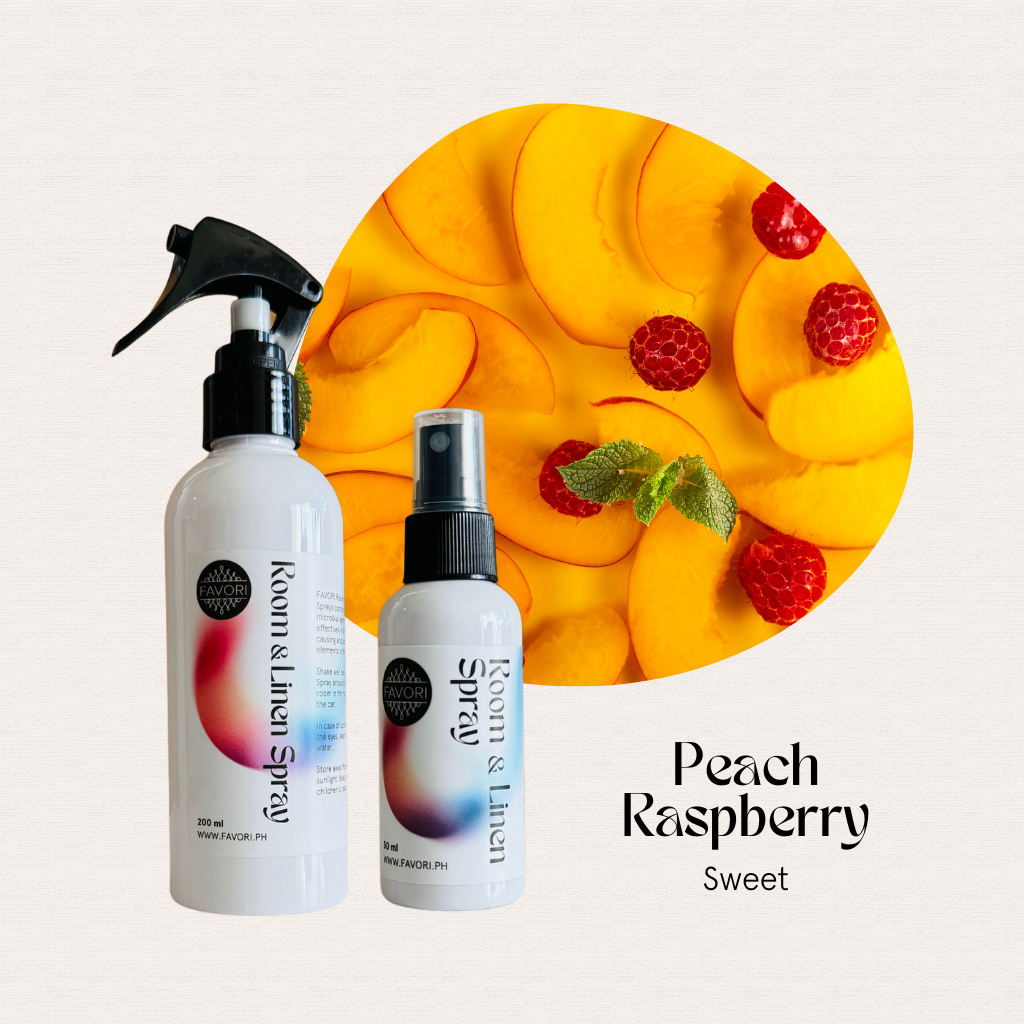 Two FAVORI Scents Regular Room & Linen Air Sprays in front of sliced peaches and raspberries.