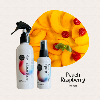 Two FAVORI Scents Regular Room & Linen Air Sprays in front of sliced peaches and raspberries.