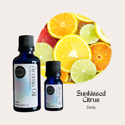 Two blue bottles of FAVORI Scents Aroma Oils, Sunkissed Citrus Zesty, beside sliced citrus.