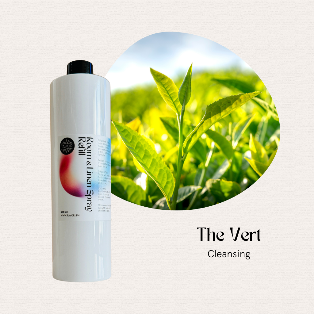 A white FAVORI Scents Refill – Regular Room & Linen Air Spray 500ml beside bright green tea leaves.
