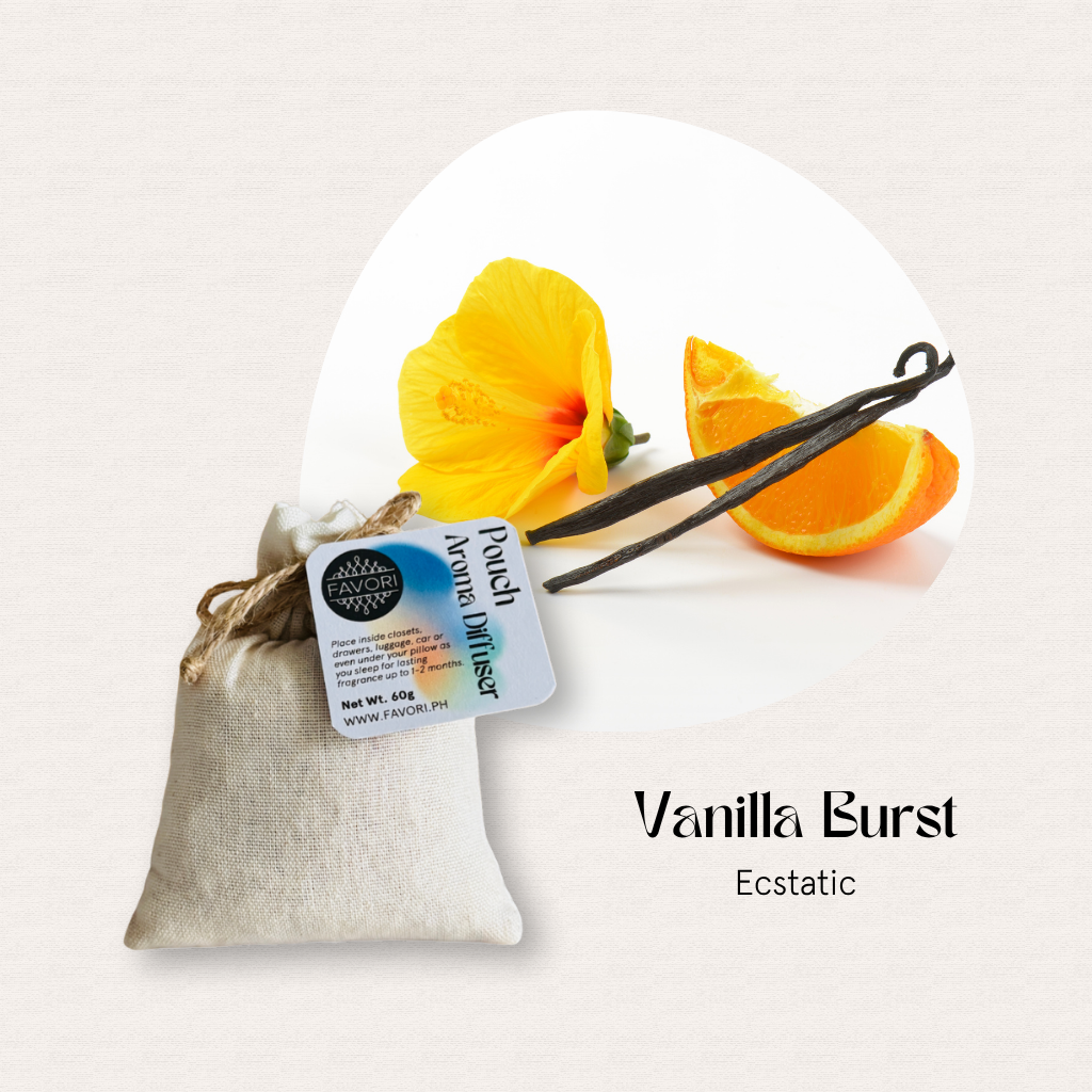 A FAVORI Scents PAD sits beside a yellow flower, orange slice, and oil on a light background.