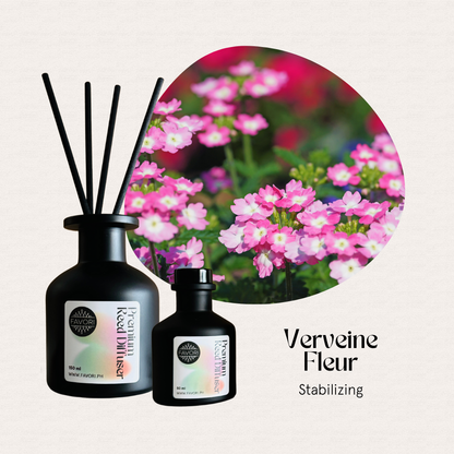 Two FAVORI Scents Verveine Fleur Premium Reed Diffusers sit in front of pink Verbena flowers.