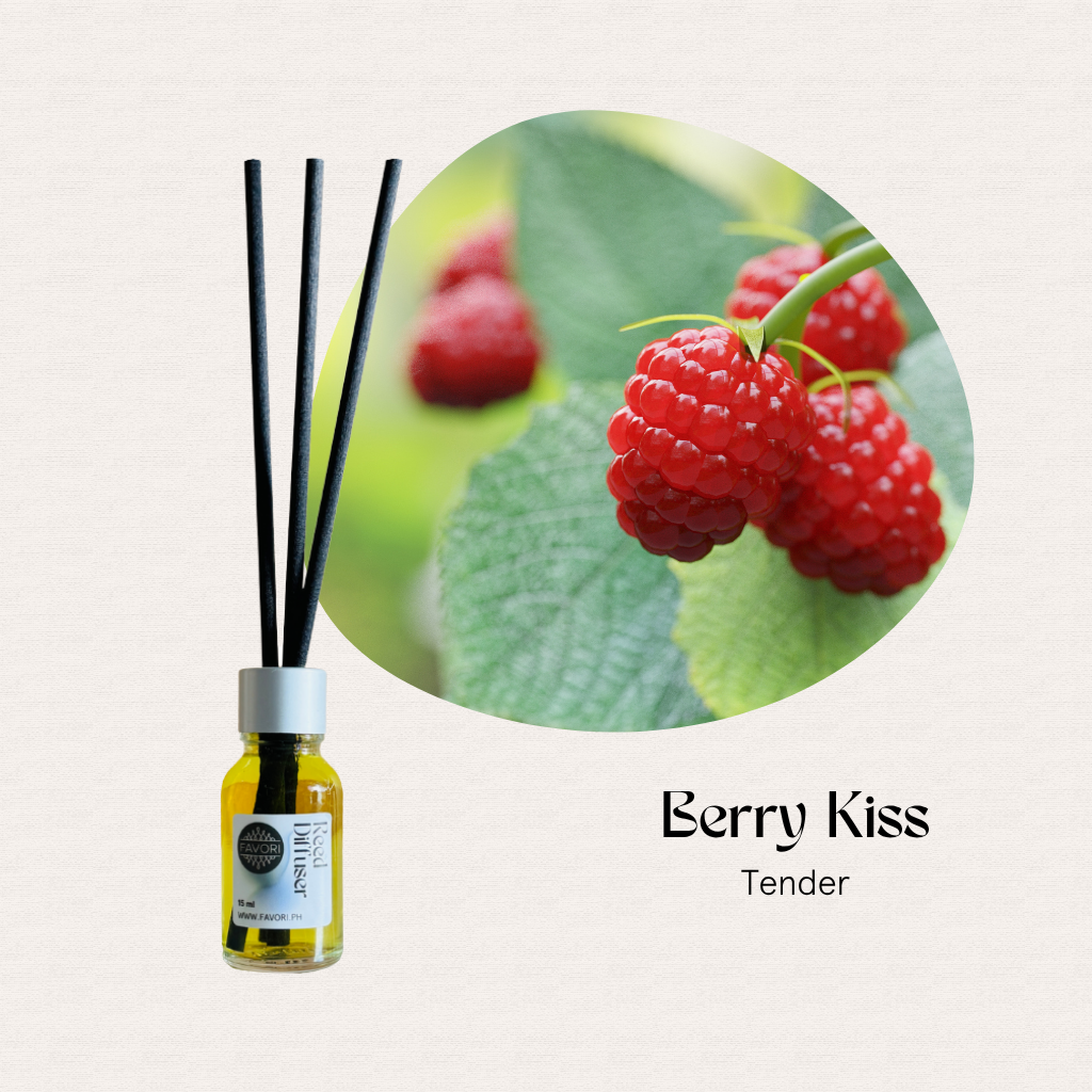 A FAVORI Scents Mini Reed Diffuser (MRD) with fiber sticks beside raspberries on a green plant.