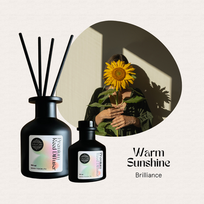Two FAVORI Scents Warm Sunshine Premium Reed Diffusers and a sunflower, text: Brilliance, long-lasting aroma.