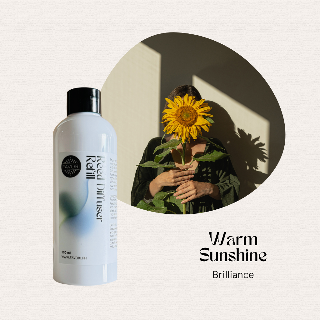 The FAVORI Scents Warm Sunshine Reed Diffuser Refill offers a long-lasting aroma beside a sunflower in sunlight.