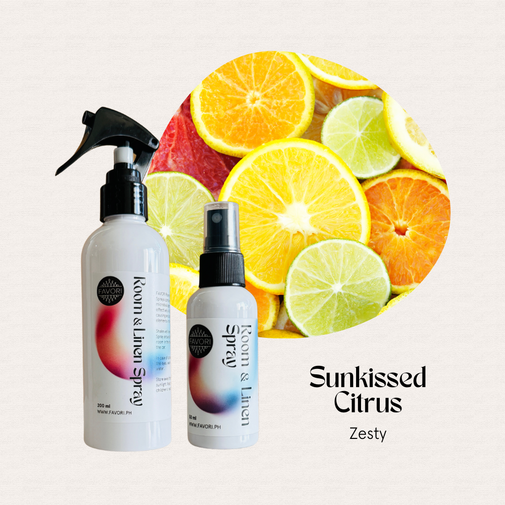 Two FAVORI Scents Regular Room & Linen Air Sprays sit by sliced citrus, evoking a Sunkissed Citrus Zesty vibe.