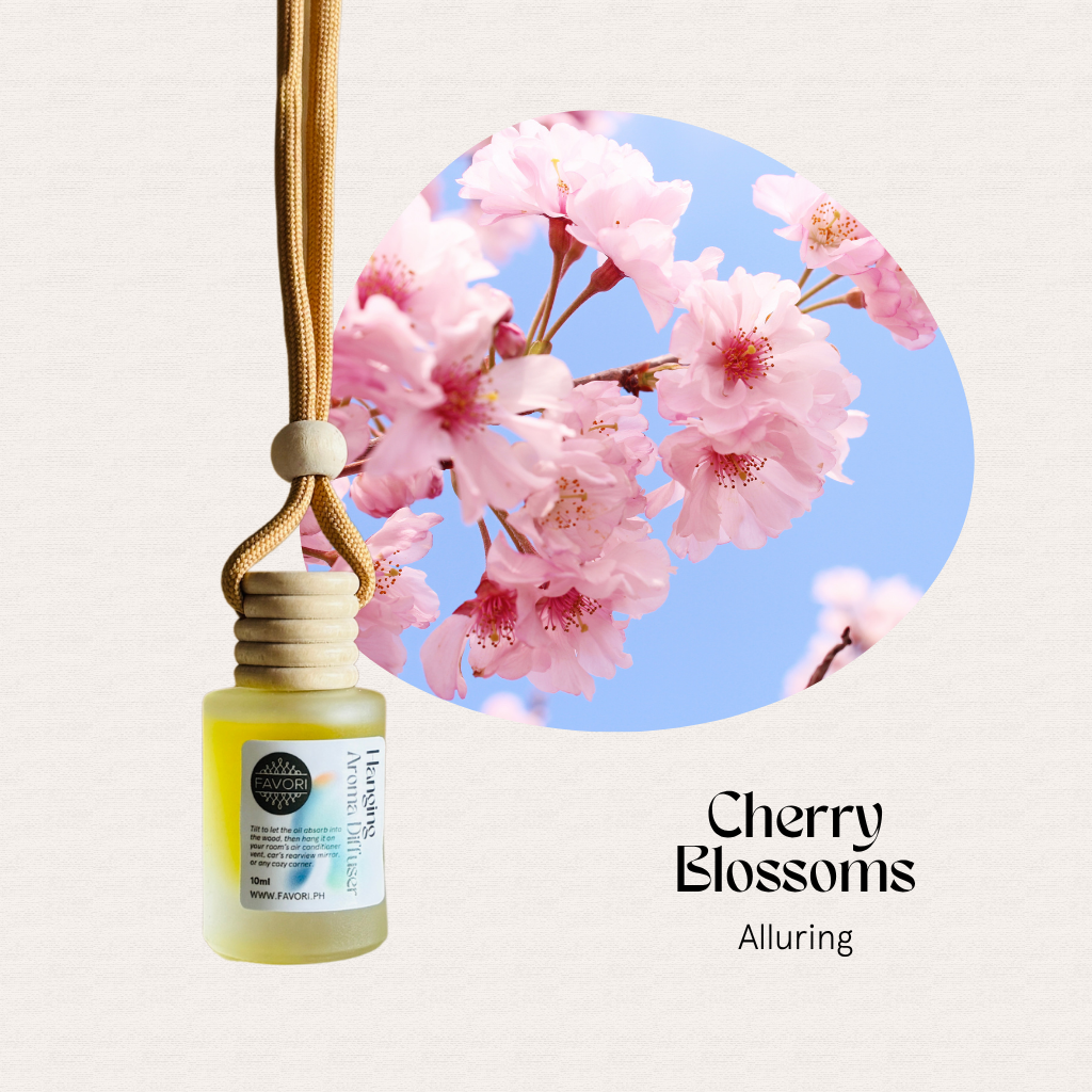 FAVORI Scents Hanging Aroma Diffusers (HAD) dangle by a cord beside cherry blossoms under a blue sky.