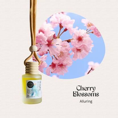 FAVORI Scents Hanging Aroma Diffusers (HAD) dangle by a cord beside cherry blossoms under a blue sky.