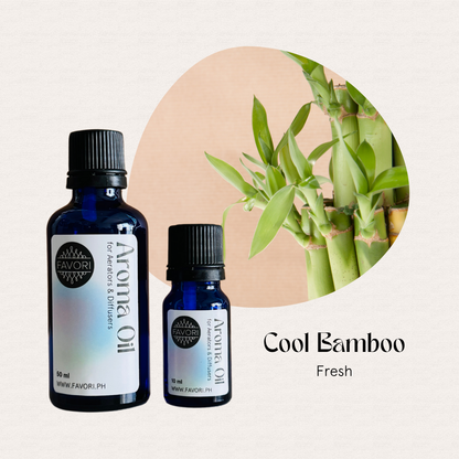 Two FAVORI Scents Aerator/Diffuser Aroma Oils next to a green bamboo plant on a light beige background.