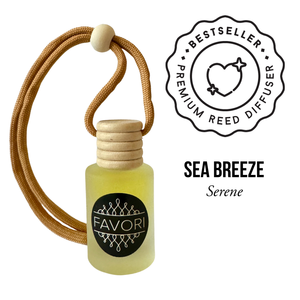 The image depicts a small, frosted glass bottle with pale yellow liquid, marked "FAVORI Scents" and topped with a wooden cap. A tan cord with a wooden bead is attached. The words "BESTSELLER," "Sea Breeze Hanging Aroma Diffuser (HAD)," and an icon of a heart with arrows encircle the bottle. Text below reads, "SEA BREEZE.