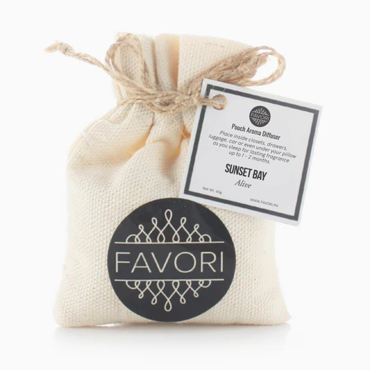 A small beige burlap pouch with a drawstring is branded with a black circular label featuring the word "FAVORI" in modern, uppercase letters. This Sunset Bay Pouch Aroma Diffuser (PAD) from FAVORI Scents includes a white product tag detailing usage instructions and the scent name "SUNSET BAY Alive," offering a long-lasting fragrance. The tag hangs from the drawstring.