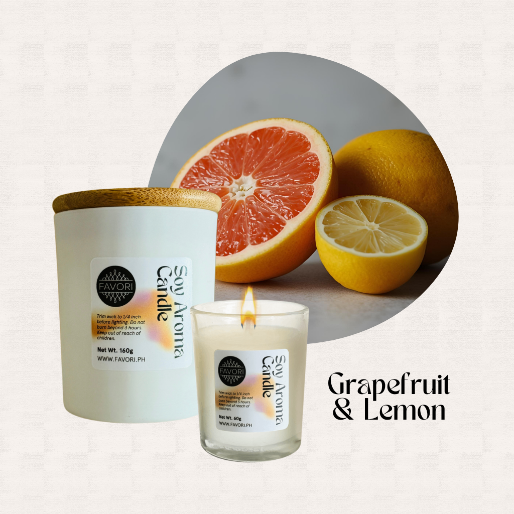 A lit FAVORI Scents All Occasion soy candle sits before sliced grapefruit and lemon.